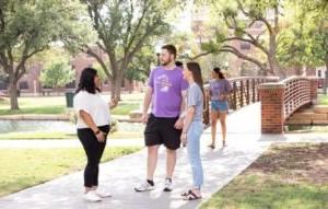 Students chatting on a sidewalk.